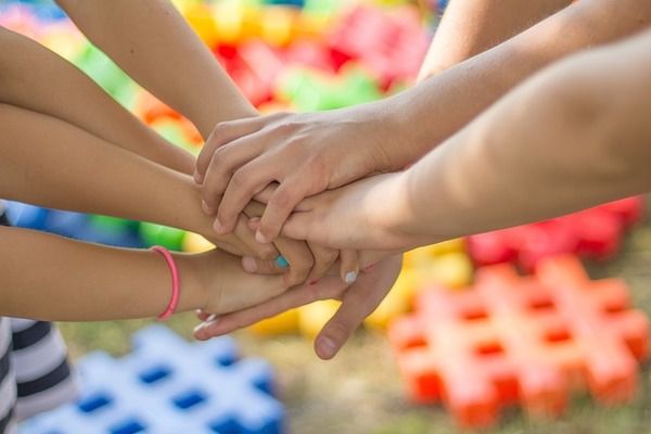 Plusieurs enfants posent leurs mains les unes sur les autres 